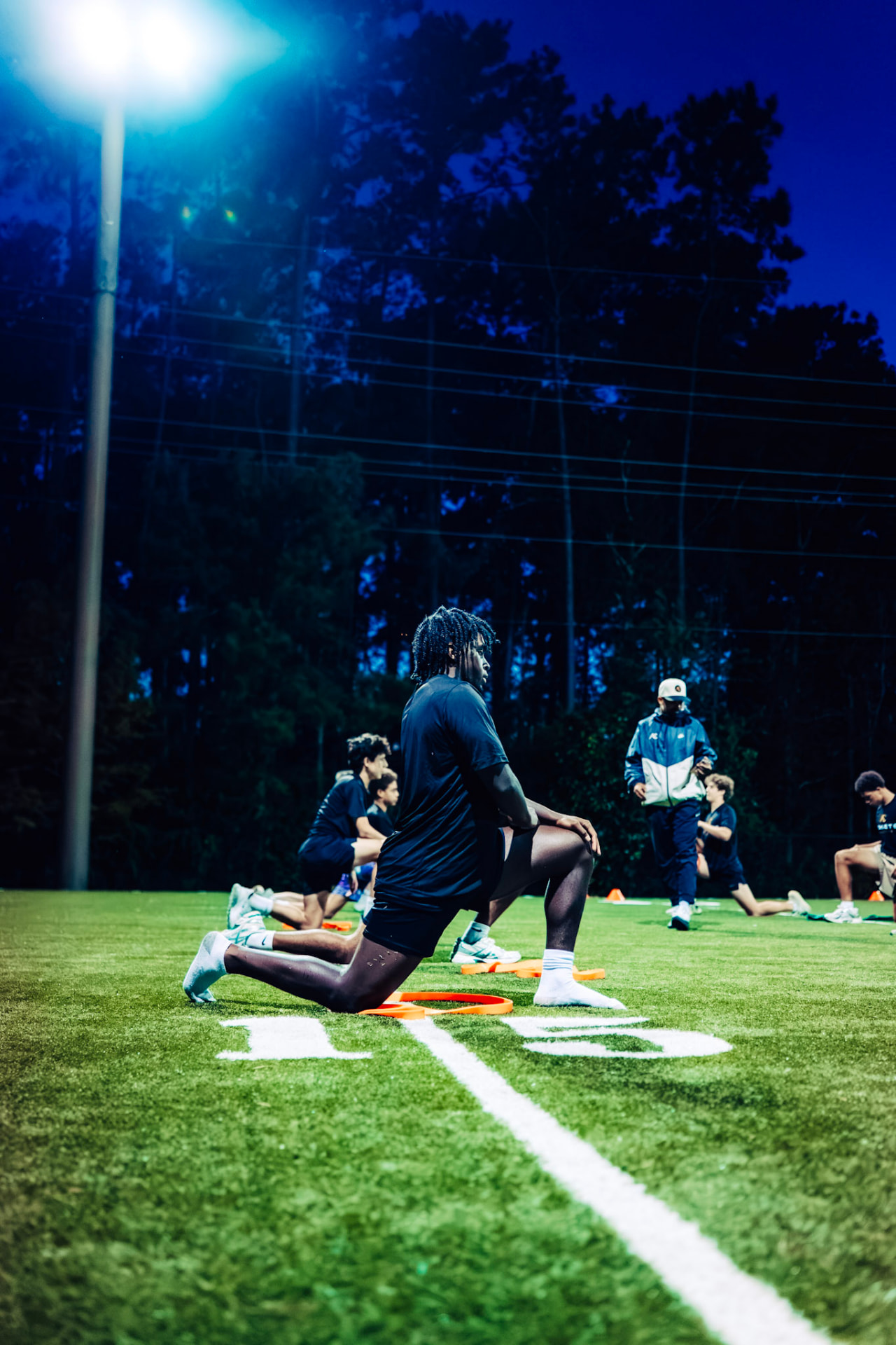 Athlete practicing movement and body control on the outdoor turf